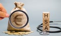 Wooden blocks with the word HSA and money bag with stethoscope. Health savings account. Health care. Health insurance. Investments Royalty Free Stock Photo