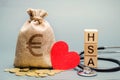 Wooden blocks with the word HSA and money bag with stethoscope. Health savings account. Health care. Health insurance. Investments Royalty Free Stock Photo