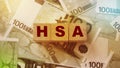 Wooden blocks with the word HSA standing for Health savings account put on 100 Euro bills. Healthcare, life insurance, medical Royalty Free Stock Photo