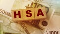 Wooden blocks with the word HSA standing for Health savings account put on 100 Euro bills. Healthcare, life insurance Royalty Free Stock Photo