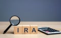 Wooden blocks with the word IRA - individual retirement account. Tax-advantaged account that individuals use to save and invest Royalty Free Stock Photo