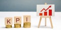 Wooden blocks with the word KPI, the graph with an arrow up. Key Performance Indicator. Planning and implementing a business Royalty Free Stock Photo