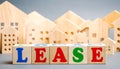 Wooden blocks with the word Lease and miniature houses. Investment activity for the acquisition of property with the right to