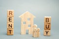 Wooden blocks with the word Rent or buy and a family stands near the house. Make the right decision. Real estate concept. Rent