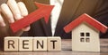 Wooden blocks with the word Rent, house and up arrow. The concept of the high cost of rent for an apartment or home. Interest