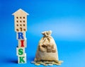 Wooden blocks with the word Risk and a miniature house with a money bag. Real estate investment risk. Risky investments. Loss of Royalty Free Stock Photo