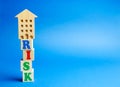 Wooden blocks with the word Risk and a miniature house. Real estate investment risk. Risky investments. Loss of property for non- Royalty Free Stock Photo