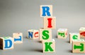 Wooden blocks with the word Risk and randomly scattered cubes. Management, cost assessment, business and investment safety. Royalty Free Stock Photo