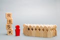 Wooden blocks with the word Risk and a team with a leader. Business concept of teamwork, crisis solution and problem management. Royalty Free Stock Photo