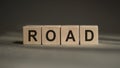 A wooden blocks with the word ROAD written on it on a gray background