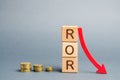 Wooden blocks with the word ROR and arrow down. Financial ratio illustrating the level of business loss. Return on investment.