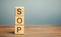 Wooden blocks with the word SOP Standard operating procedure . Instructions to assist employees in complex routine operations.