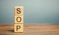 Wooden blocks with the word SOP Standard operating procedure . Instructions to assist employees in complex routine operations.