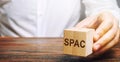 Wooden blocks with the word SPAC - Special purpose acquisition company. Simplified listing of company, merger bypassing stock