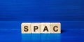 Wooden blocks with the word SPAC - Special purpose acquisition company. Simplified listing of company, merger bypassing stock