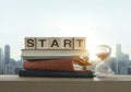 Wooden blocks with the word START, notebook, books and sand clock on table with panoramic city skyline background in the morning. Royalty Free Stock Photo