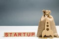 Wooden blocks with the word Startup and Rocket. The concept of raising funds for a startup. Charitable contributions to translate