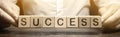 Wooden blocks with the word Success and businessman. Successful business concept. Achieving the goal, overcoming difficulties. The