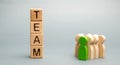 Wooden blocks with the word Team and a crowd of workers with a leader. The concept of a strong reliable business team. Teamwork.