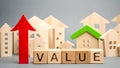 Wooden blocks with the word Value, up arrow and wooden houses. The concept of raising property prices. High cost for rental