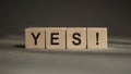 A wooden blocks with the word YES written on it on a gray background. Business concept Royalty Free Stock Photo