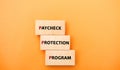 Wooden blocks with words Paycheck Protection Program. Loan that helps businesses keep their workforce employed during the COVID-19 Royalty Free Stock Photo