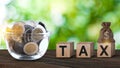 Wooden blocks with the words Tax and US dollar money bag and coins, Taxes payment concept. Tax evasion. Taxation. Business and Royalty Free Stock Photo