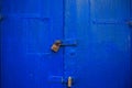 Wooden blue door background locked with two rusty padlocks. Aged, closed entrance, close up view with details. Royalty Free Stock Photo