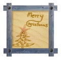 Wooden blue frame with nails in shape of sun against a white background with Christmas tree and words Merry Christmas on sandy ba Royalty Free Stock Photo