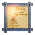 Wooden blue frame with nails in shape of sun against a white background with Christmas tree and words Merry Christmas on sandy, s Royalty Free Stock Photo