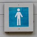 A wooden blue male bathroom sign