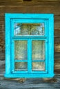 Wooden blue window shutters on the wall of an old dilapidated wooden house in the village. The destroyed abandoned dwelling after Royalty Free Stock Photo