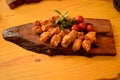 A wooden board with breaded chicken skewers, cherry tomatoes and sprigs of basil and rosemary Royalty Free Stock Photo