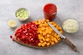 Wooden board with chopped sweet peppers and pumpkin, chopped onion, celery, garlic and tomato sauce on a gray textured Royalty Free Stock Photo