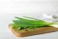 Wooden board with cut fresh green onions on white. Space for text Royalty Free Stock Photo