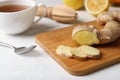 Wooden board with cut ginger on table. Royalty Free Stock Photo