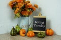 Giving Tuesday typography text with Artificial flowers and pumpkin on wooden table interior decoration Royalty Free Stock Photo