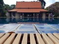 Wooden board empty table against of blurred swimming pool background Royalty Free Stock Photo