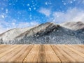 Wooden board empty table top on of blurred snowfall background. Perspective brown wood table over blur winter blue landscape. Royalty Free Stock Photo