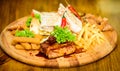 Wooden board french fries fish sticks burrito and meat steak served with salad. Pub menu snack. Enjoy your meal. Meat