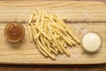 Wooden board with French fries and sauces Royalty Free Stock Photo