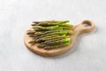 Wooden board of fresh asparagus on a light blue background, home cooking, top view Royalty Free Stock Photo