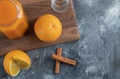 A wooden board with a glass jug of juice and orange fruits Royalty Free Stock Photo