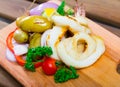 Wooden board with grilled squid rings