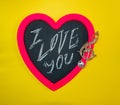 Wooden board for inscriptions chalk in shape of pink heart with various festive accessories and written text I love you Royalty Free Stock Photo