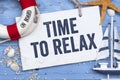 Wooden board with maritime decoration and the words time to relax