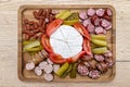 Wooden board with pieces of meat, blue cheese and vegetables, on the kitchen counter, top view. Royalty Free Stock Photo