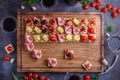 Wooden board with pinxtos or tapas with jamon, ham and sausage, flat lay Royalty Free Stock Photo