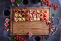 Wooden board with pinxtos or tapas with jamon, ham and sausage, flat lay Royalty Free Stock Photo