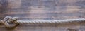 Wooden board with a rough texture and a rope Royalty Free Stock Photo